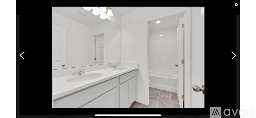 A bathroom with a sink, mirror, and a door.