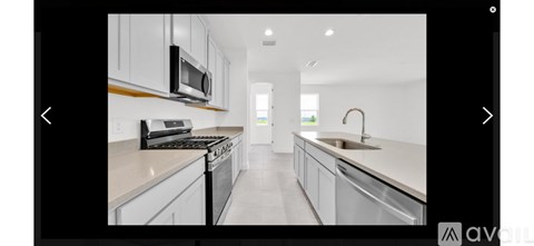 A modern kitchen with white cabinets and a stainless steel oven.