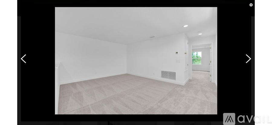 A room with a carpeted floor and a white wall.