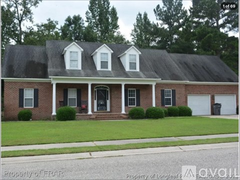 A brick house with a black roof and a white door.