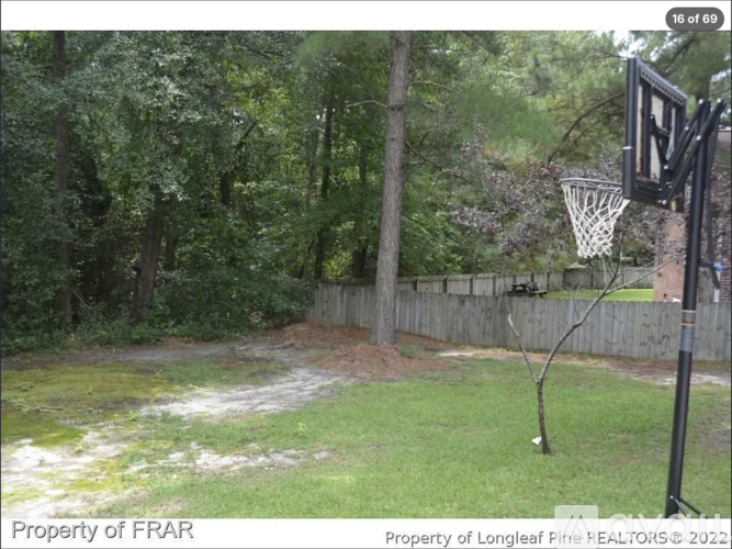 A basketball hoop is set up in a grassy yard.
