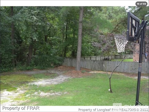 A basketball hoop is set up in a grassy yard.