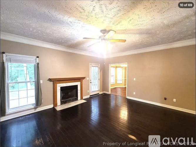 A living room with a fireplace and a ceiling fan.