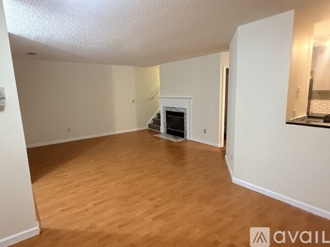 A spacious living room with hardwood floors and a fireplace.