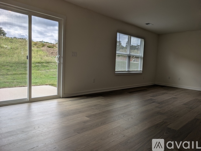 A room with a sliding glass door leading to a grassy area.