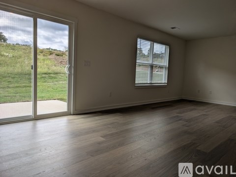 A room with a sliding glass door leading to a grassy area.
