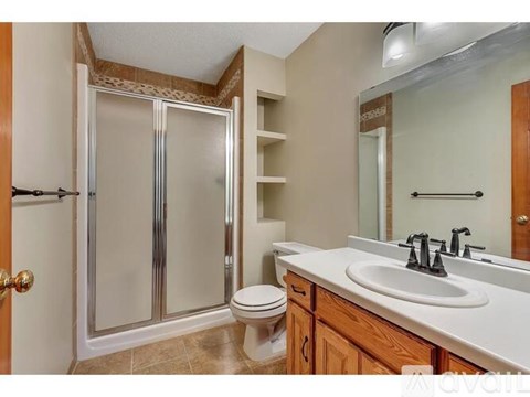A bathroom with a toilet, sink, and shower.