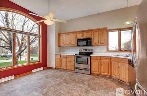 A kitchen with wooden cabinets and a tiled floor.