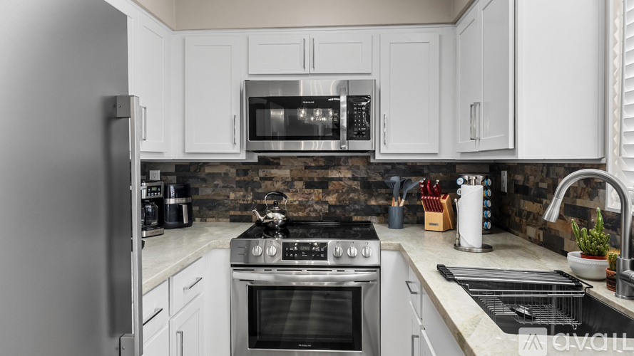 A kitchen with white cabinets and stainless steel appliances.