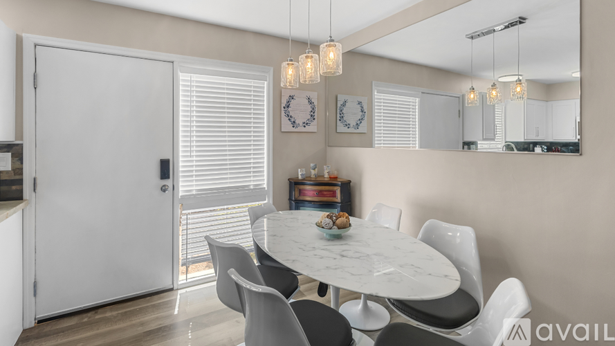 A modern dining room with a round table and chairs.