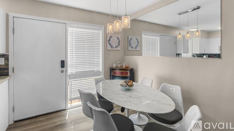 A modern dining room with a round table and chairs.