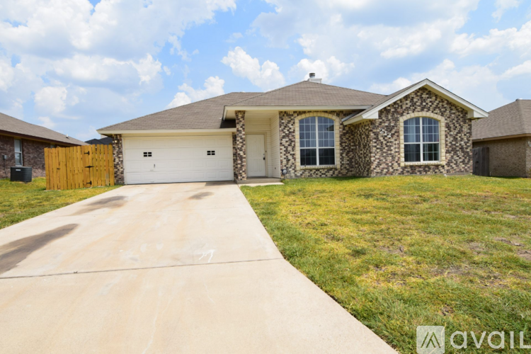 A house with a garage and a driveway in front of it.
