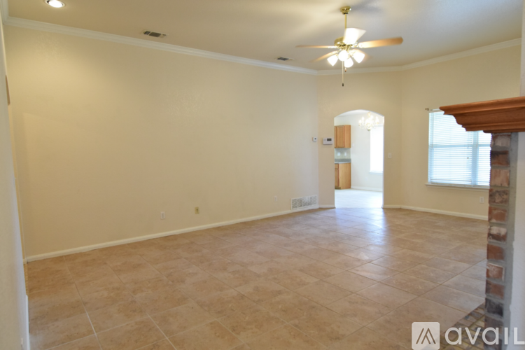 A spacious room with a ceiling fan and tiled floor.
