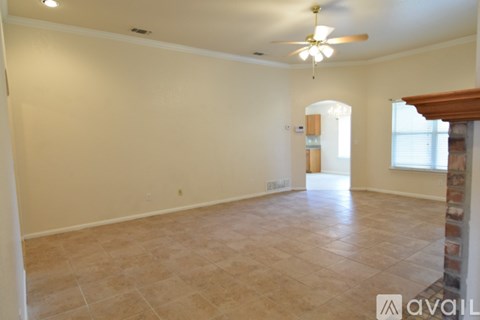 A spacious room with a ceiling fan and tiled floor.