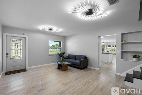 A living room with a couch, a coffee table, and a window.