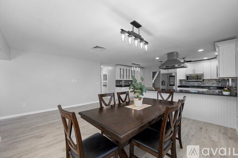 A modern kitchen with a dining table and chairs in the foreground.