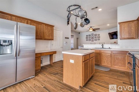A kitchen with wooden cabinets and a stainless steel refrigerator.