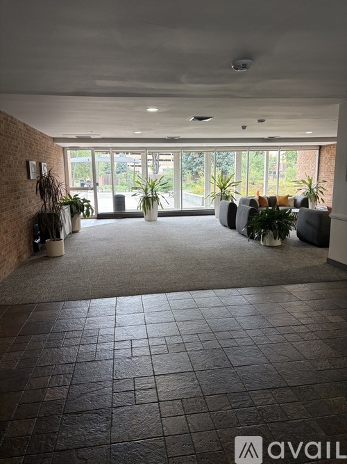 A spacious waiting area with grey couches and a brick wall.