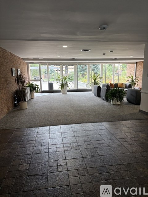 A spacious waiting area with grey couches and a brick wall.