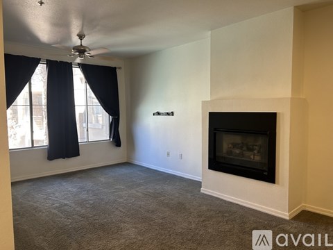 A living room with a fireplace and a ceiling fan.