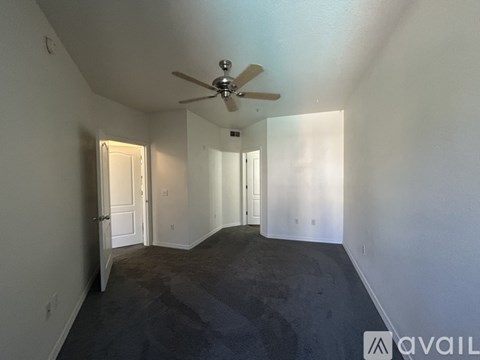 A spacious room with a ceiling fan and carpeted floor.