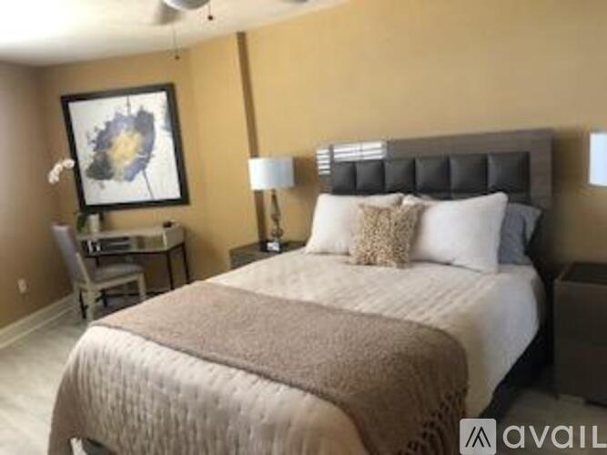 A bedroom with a large bed and a painting on the wall.