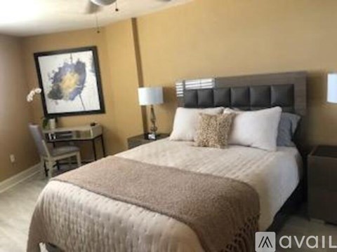 A bedroom with a large bed and a painting on the wall.
