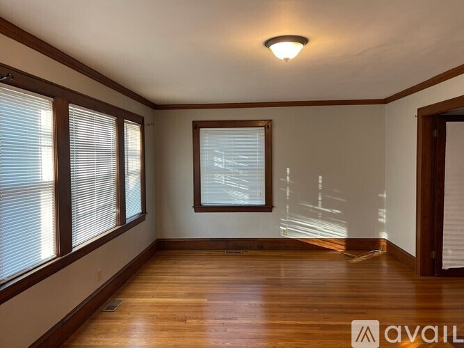 A room with wooden floors and a window with blinds.