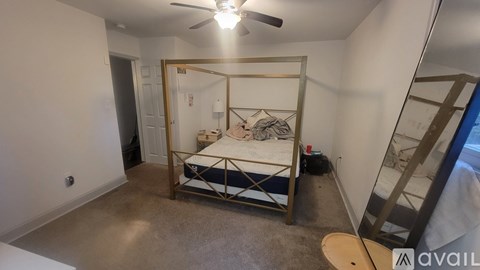 A bedroom with a bed and a ceiling fan.