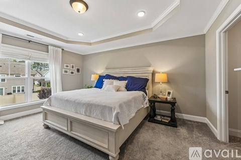 A bedroom with a large bed and a window overlooking a cityscape.