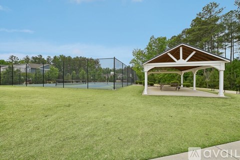 A gazebo sits in the middle of a grassy field.