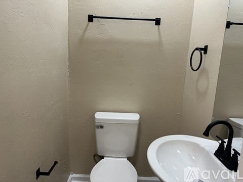 A white toilet and sink in a bathroom.