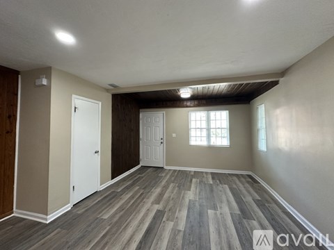A room with wooden flooring and a window.