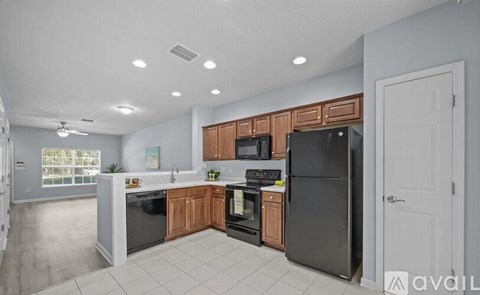 A kitchen with wooden cabinets and black appliances.