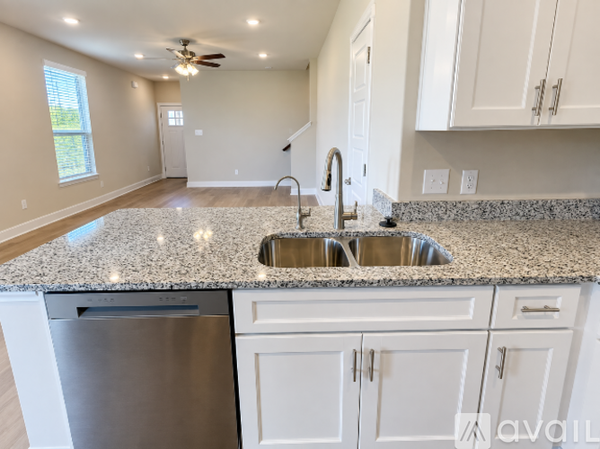 A kitchen with granite countertops and white cabinets.