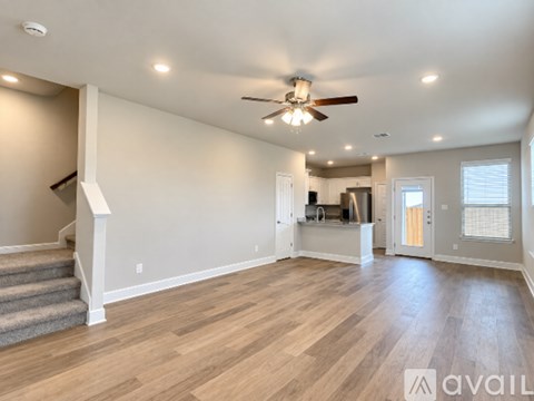 A spacious room with a ceiling fan and lighting fixtures.