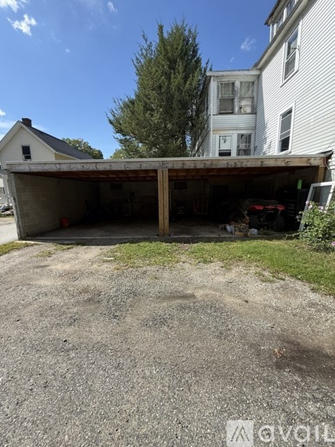 A large garage is attached to a white house.