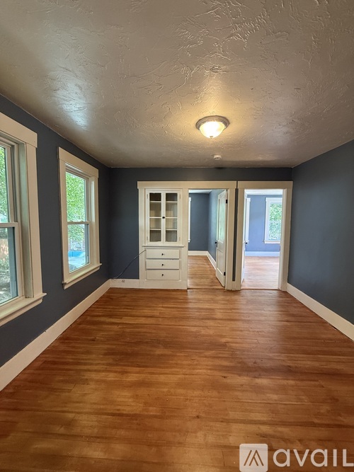 A room with wooden floors and a white dresser.