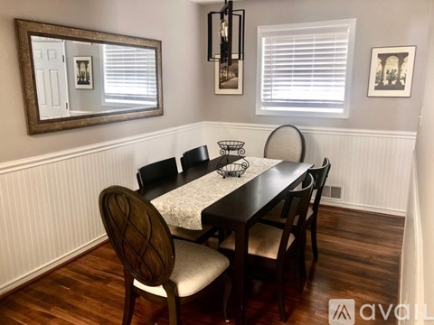 A dining room with a wooden table and chairs.