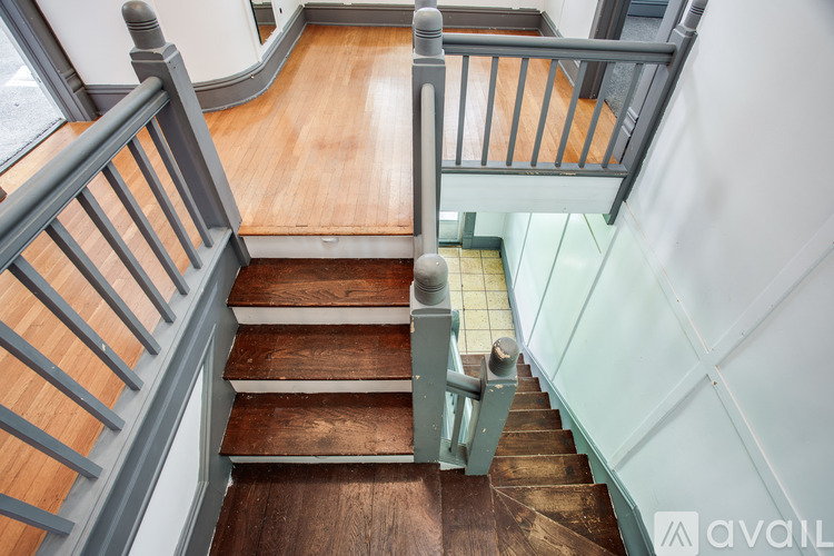 A wooden staircase with a metal railing.