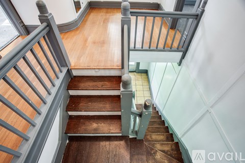 A wooden staircase with a metal railing.