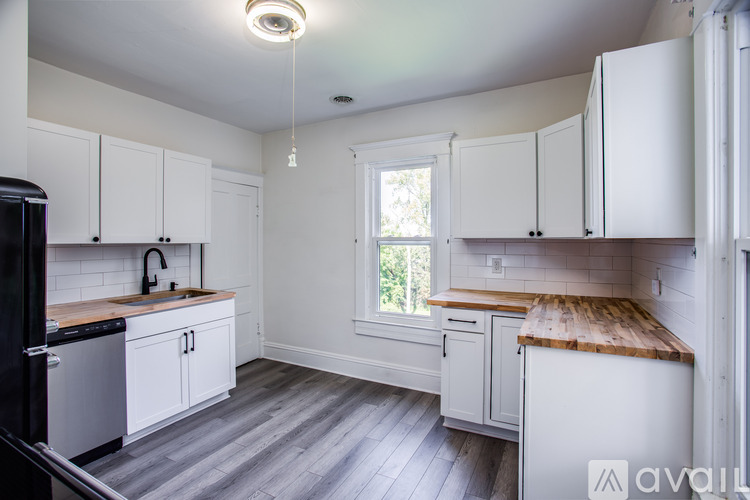 A kitchen with white cabinets and a wooden countertop.