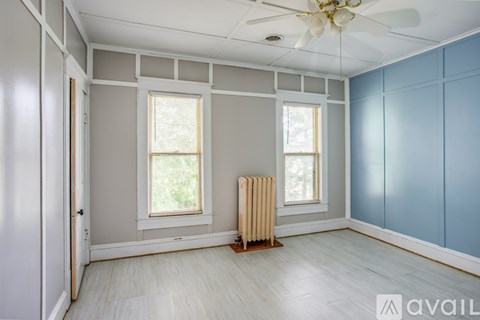 A room with a window, a radiator, and a ceiling fan.