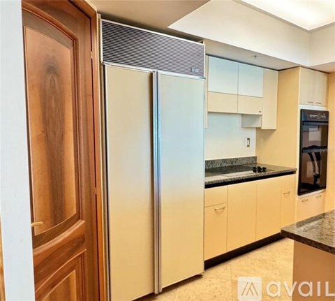 A kitchen with a refrigerator, cabinets, and a countertop.