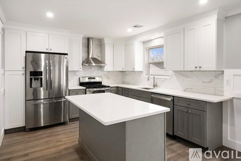 A modern kitchen with a stainless steel refrigerator and a central island.