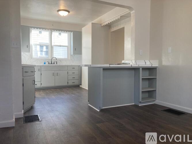 A kitchen with white cabinets and a grey island.