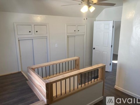 A room with a wooden balcony and two white doors.