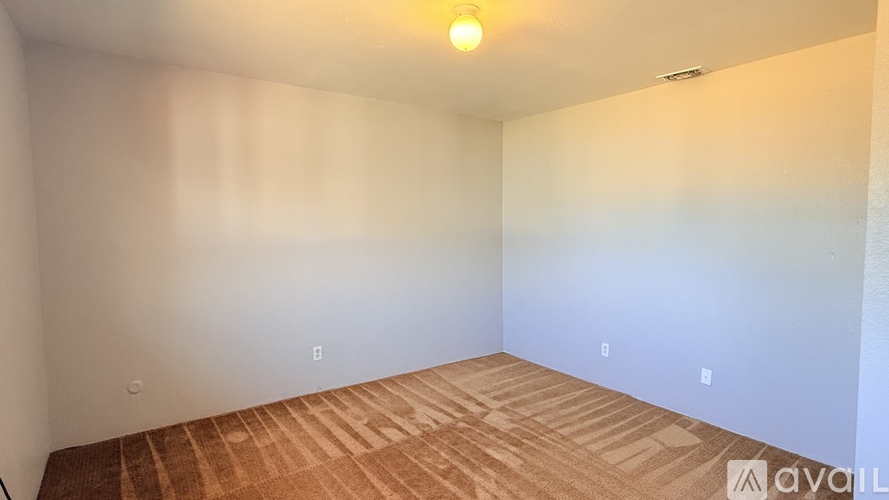 A room with wooden flooring and white walls.