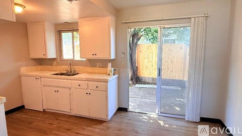 A kitchen with white cabinets and a sink.