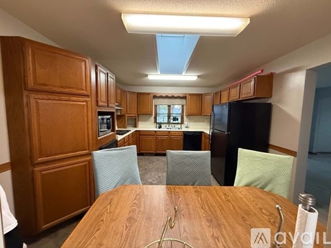 A kitchen with wooden cabinets and a table in the foreground.